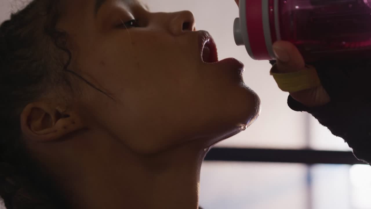 Primo piano di una donna di etnia mista che beve acqua