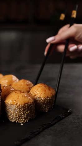 woman eating sushi with chopsticks