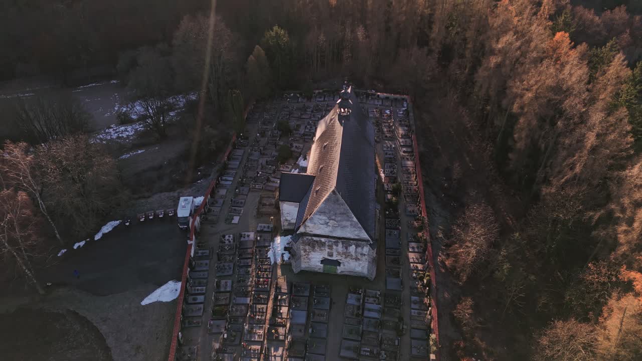 Drone's descending camera reveals a mysterious face emerging from the plaster of a church in Velhartice