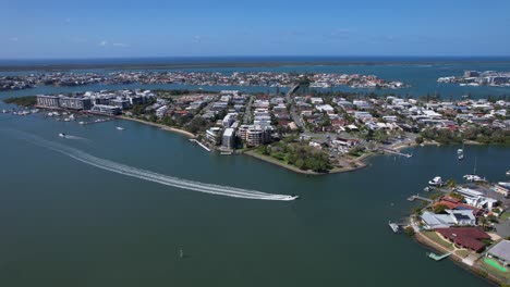 una lancha rápida navegando en el mar azul dejando una estela en paradise point en queensland, australia.
