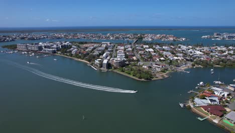 speedboat cruising in the blue sea leaving wake behind at paradise point in queensland, australia