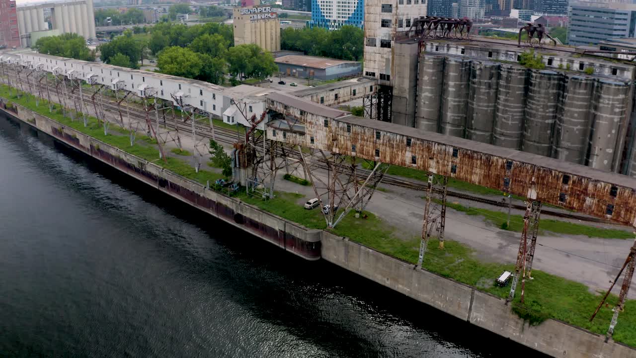 Aerial shot of an old shipping yard in Montreal, featuring rows of weathered containers and industrial cranes. Captures the raw, historical charm of the port's past operations.