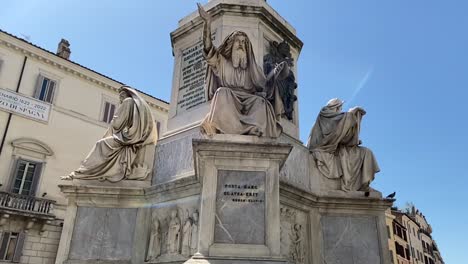 biblical column of the immaculate conception with the statue of ezekiel the seer in rome, italy near the spanish steps with a blue sky background