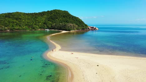 Sunbeds-and-umbrellas-on-white-sandy-beach-washed-by-calm-turquoise-lagoon-on-beautiful-coastline-of-tropical-island-in-Cambodia