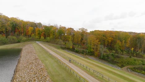 Rising-aerial-shot-of-bicycle-riding-on-reservoir-trail