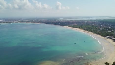 bali indonesia beautiful jimbaran bay beach with clear blue ocean aerial panning drone