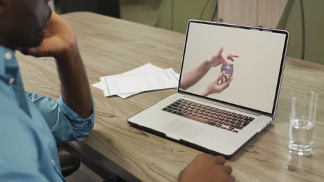 African-american-man-at-table-using-laptop,-online-shopping-for-beauty-products,-slow-motion