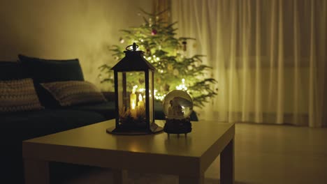 una vista de una linterna de vela, un globo de nieve y un árbol de navidad - toma estática