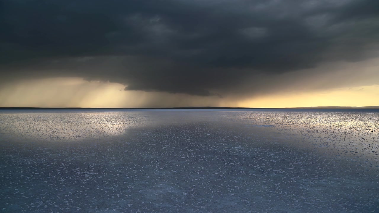 Storm Clouds Gathering Over a Vast Salt Lake at Sunset