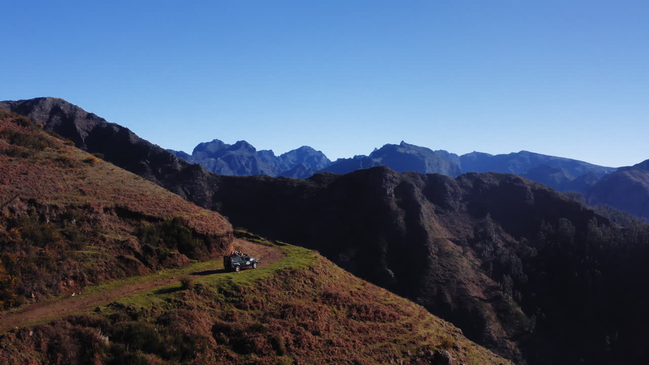 마데이라 산맥에서 높이 운전하는 오프로드 트럭의 공중 전망 - 상승, 팬 드론 샷