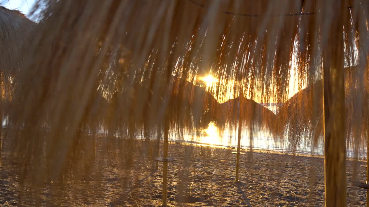 밀짚 파라솔 4k를 통한 선라이즈 마르베야 비치 짐벌 부드러운 움직임