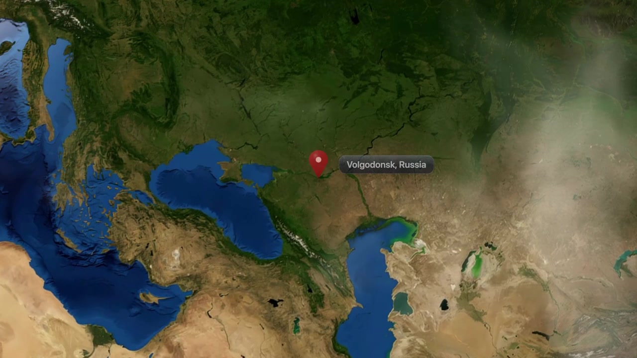 Satellite animation zooms from space into the globe, pinpointing Volgodonsk, Russia with a marker. Includes NASA public domain imagery.