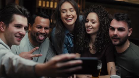 handheld video of friends taking selfie in the pub.