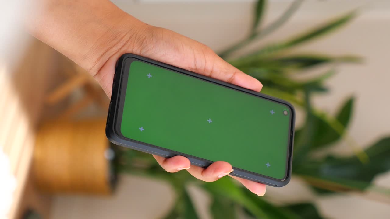 Phone with green screen held in hand