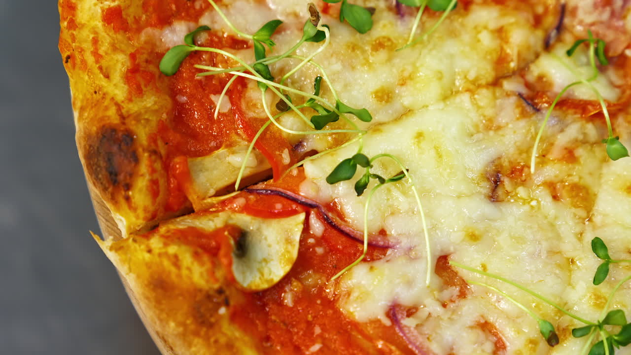 Appetizing pizza. Delicious pastry with bacon, onions, tomatoes and melted cheese. Green sprouts on ready pizza in the restaurant. Macro shot.