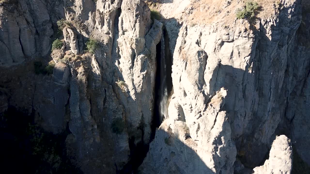 Riprese aeree 4K di una cascata che scorre tra formazioni rocciose