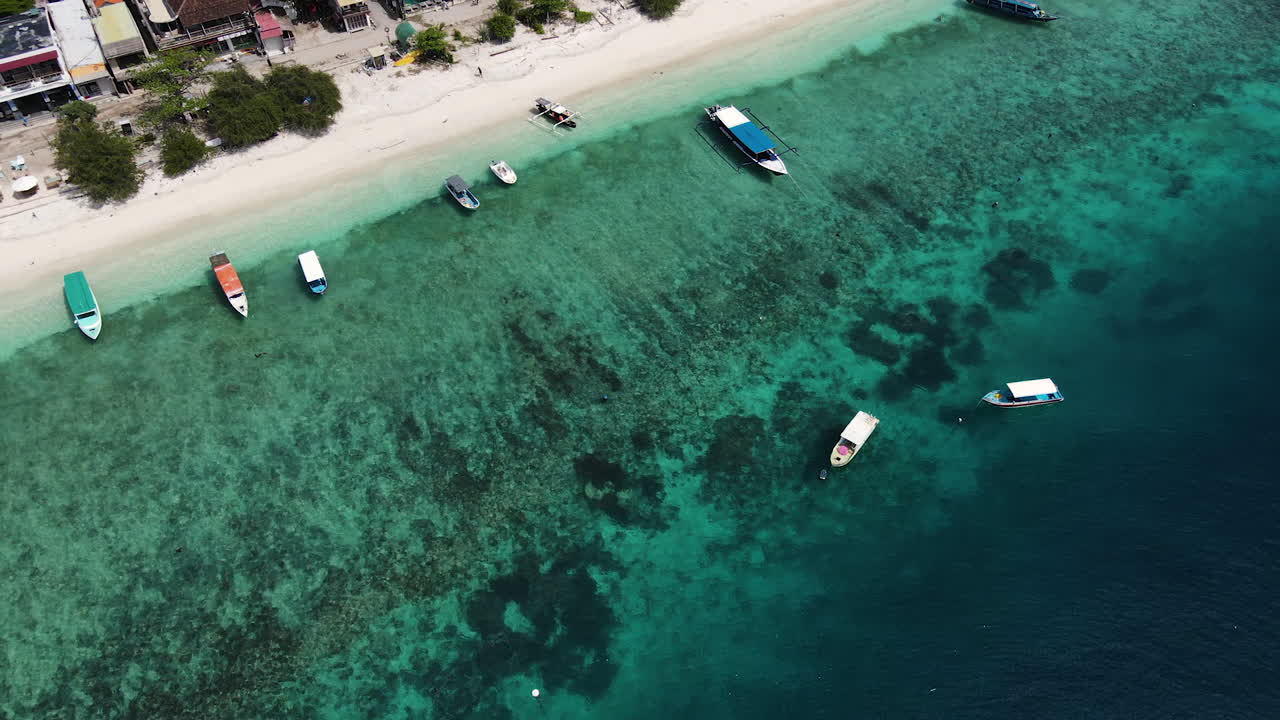 barcos coloridos y estructuras de casas en la costa de la isla de gili meno en indonesia
