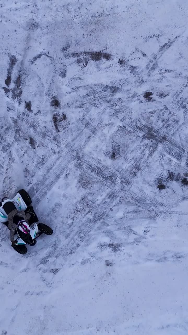 Un bambino guida un quad su una superficie innevata