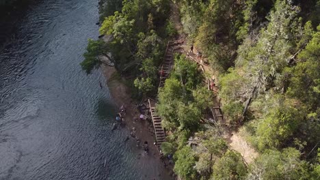 People-are-climbing-stairways-bear-the-river-bank,-location-captured-at-Patagonia,-Argentina