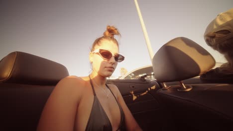 woman in a convertible wearing sunglasses