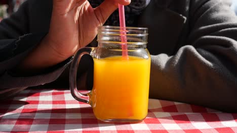 un vaso de jugo de naranja en un mantel de cuadros rojos