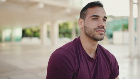 young man looking at camera and smiling outdoors.