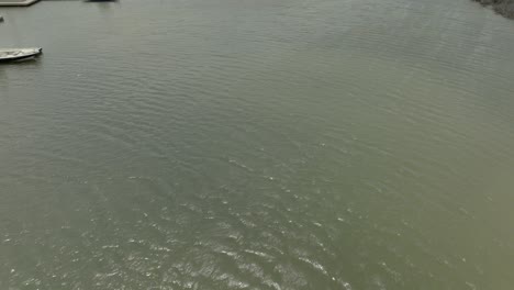 Aerial-view-of-Cove-harbor-Marina-and-center-console-boat-heading-out-on-an-overcast-day-in-4K