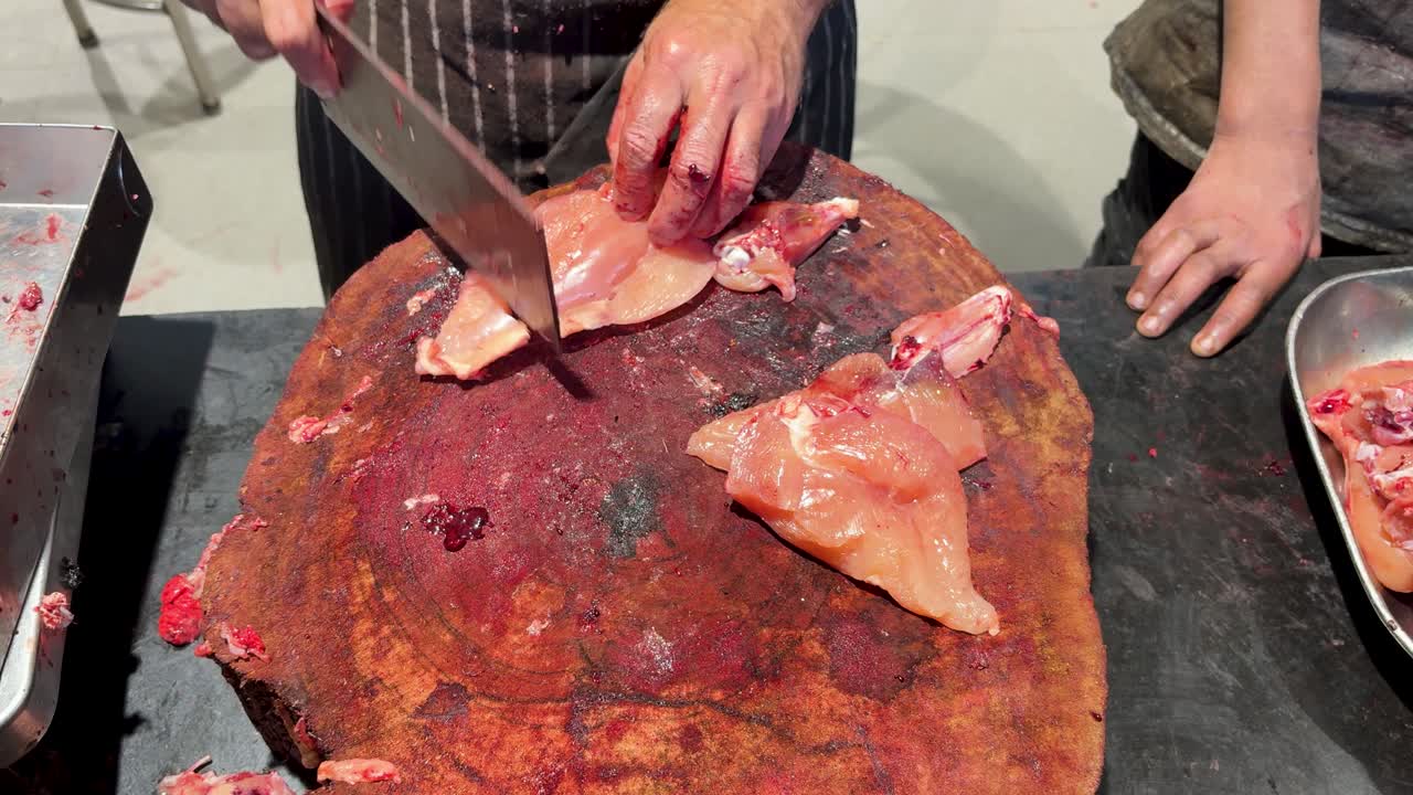 Processo di taglio della carne con pollo crudo e mannaia su tagliere di legno