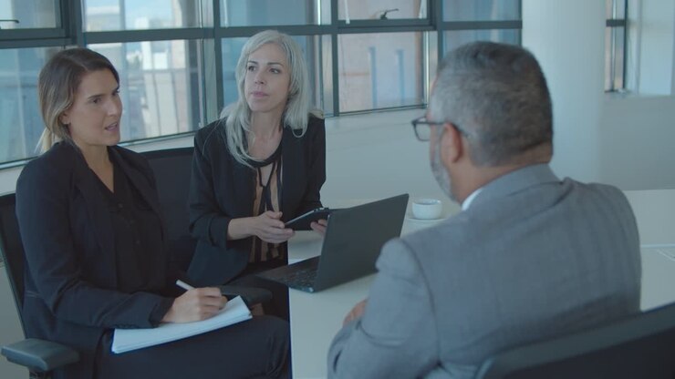 Male professional talking to female managers