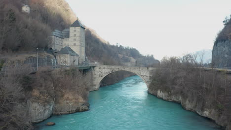 aerial old bridge crossing a wild and blue river