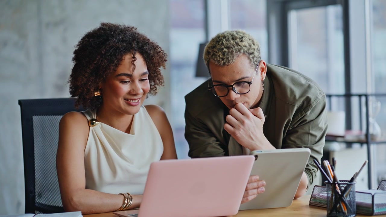 Man and woman reviewing project laptop tablet office. Coworkers share ideas.