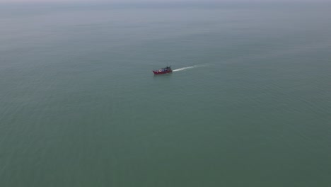 Toma-Aérea-De-Un-Barco-De-Pesca-En-Medio-Del-Mar-Pescando