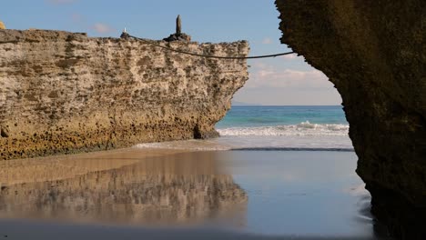 Paisaje-Oceánico-Tranquilo-Y-Relajante-Al-Aire-Libre-Con-Rocas-Y-Olas-Rodando-Lentamente-Hacia-Una-Pequeña-Ensenada