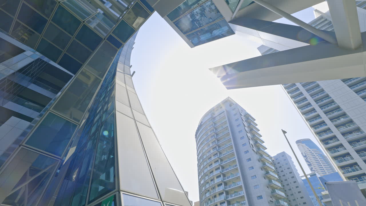 Low-angle view of modern glass and steel city buildings