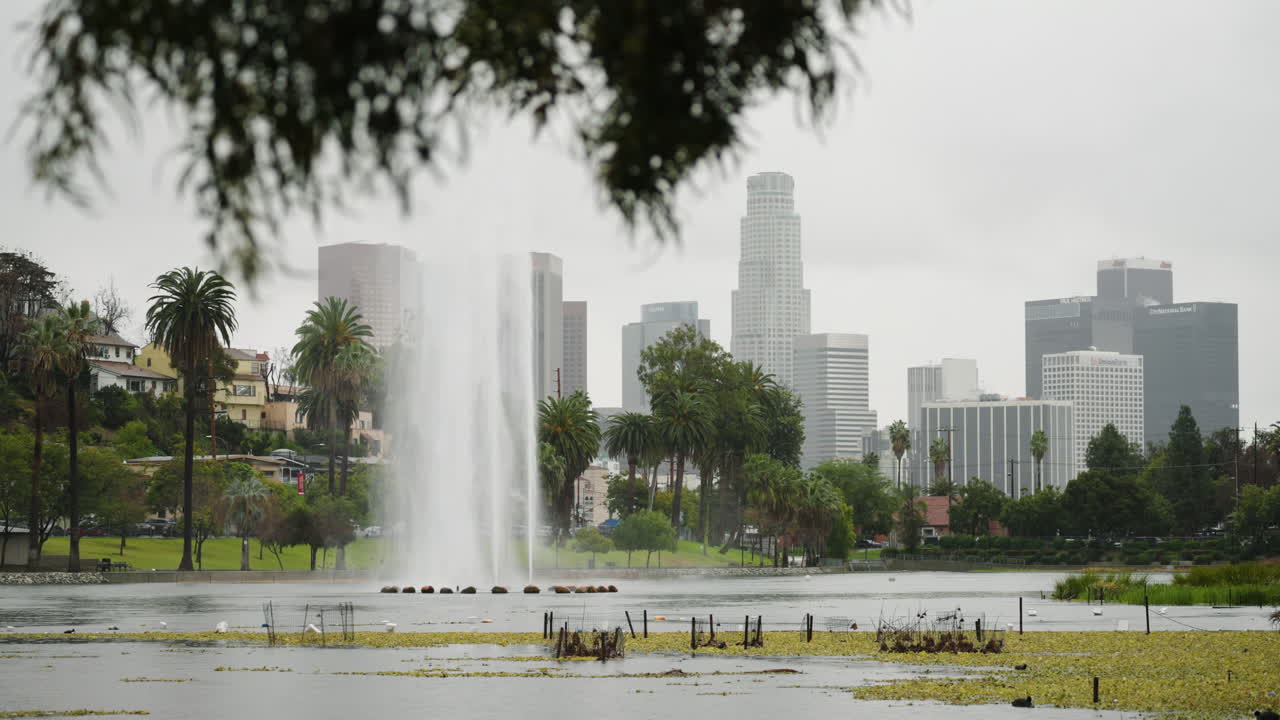 una toma amplia del lago echo park bajo la lluvia con el horizonte del centro de la ciudad al fondo