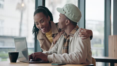 happy black couple on laptop in cafe