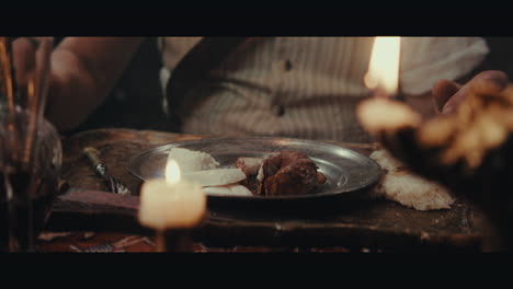 an old pirate eats and drinks inside the sailing ship cabin