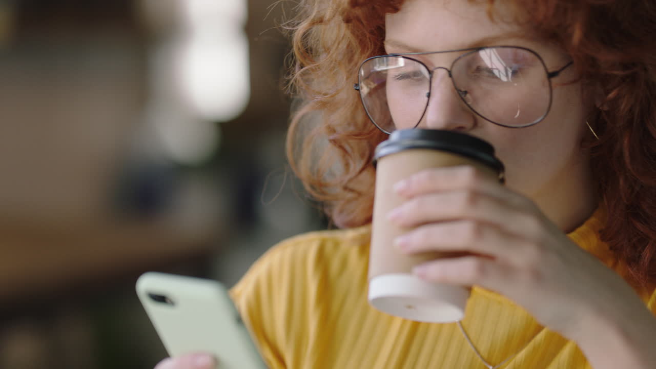 retrato hermosa joven pelirroja usando teléfono inteligente en un café navegando en línea mensajes de redes sociales disfrutando de beber café compartiendo estilo de vida leyendo teléfono móvil comunicación usando gafas