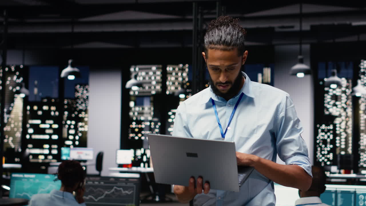 Portrait of smiling middle eastern employee standing in office reading emails