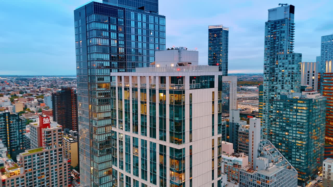New York, USA, 8 ottobre 2025: grattacieli con le luci accese alle finestre. Filmato aereo con drone sulla sommità degli edifici di New York al crepuscolo