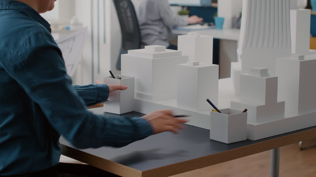 Architecture Team Reviewing Building Model and Blueprints