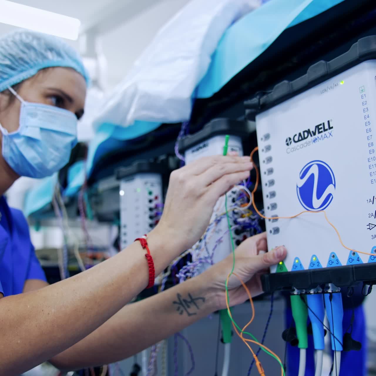Doctor sets the apparatuses for EMG and ECG during neurosurgery. Close up. Medic inserting electrodes into slots