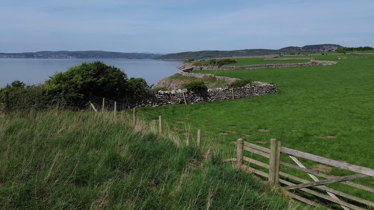 Lake district coastal farming meadow aerial view across fence and stone wall boundary Morecambe bay