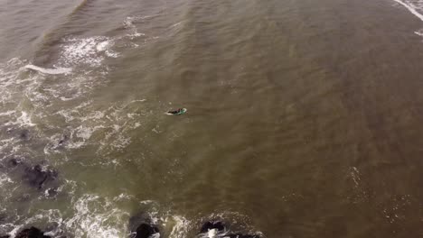 Vista-Aérea-De-Un-Surfista-Entrando-En-Los-Mares-Agitados-Del-Océano-Atlántico-En-Punta-Del-Este-En-Uruguay