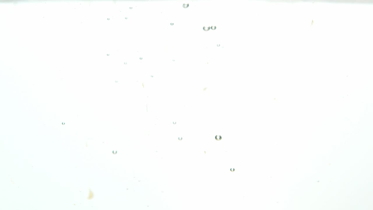 montón de cerezas rojas cayó en agua líquida, aislado sobre fondo blanco.