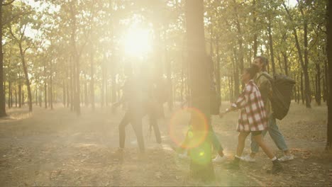 Side-view-of-a-group-of-six-people-in-special-hiking-clothes-and-with-backpacks-walking-through-the-summer-forest-during-their-hike.-Happy-people-wearing-plaid-shirts-and-walking-through-the-forest-in-summer