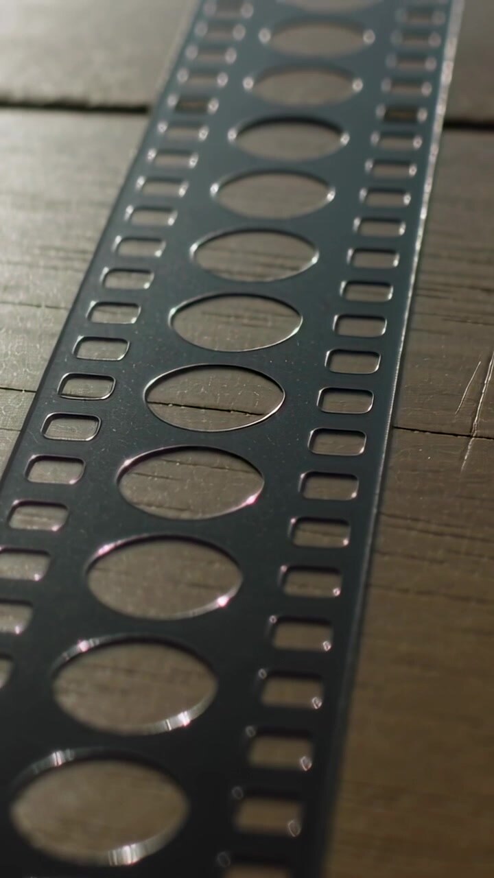 Video verticale: la telecamera si sposta lungo un piano del tavolo in legno all'inizio, rivelando una striscia perforata
