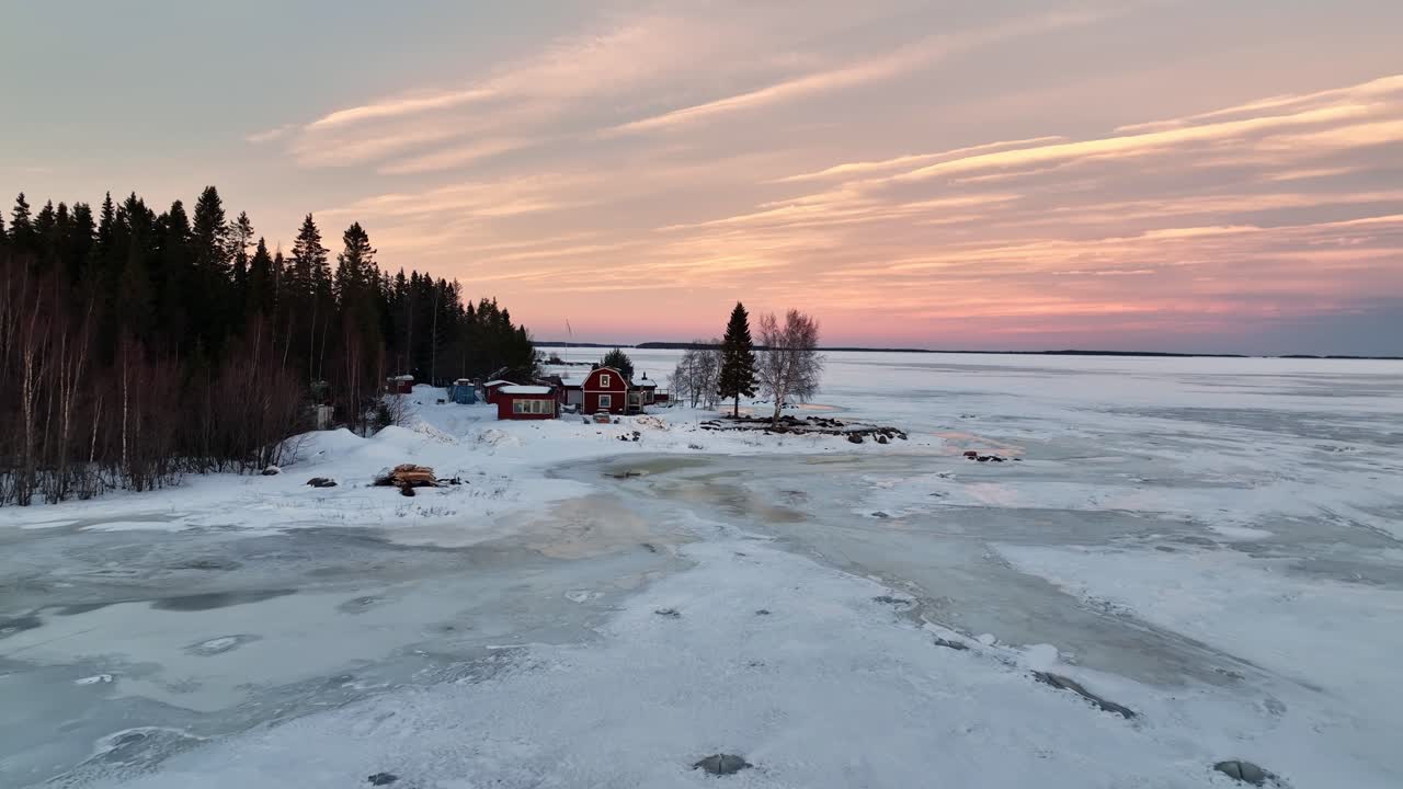 Bahía congelada al anochecer con casas rojas, Bahía de Botnia cerca de Luleå, Suecia, serena