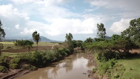 Drohnenansicht-Eines-Kleinen-Flusses,-Der-Durch-Bauernhöfe-In-Äthiopien-Fließt