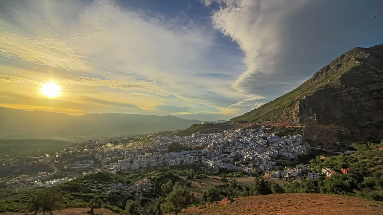 tiro de lapso de tiempo de la hermosa puesta de sol dorada sobre la antigua ciudad de chefchaoen en áfrica - vista panorámica de la ciudad de iluminación entre montañas